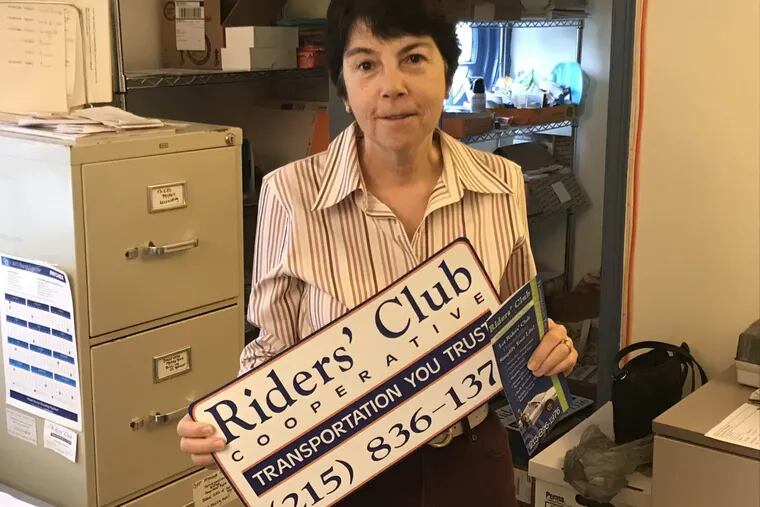 Riders’ Club Co-op is a nonprofit members group based in Montgomery County that offers rides to seniors, as well as to children with disabilities. Drivers carry this sign, held here by assistant Marianne Fluehr at the organization’s headquarters in Erdenheim.