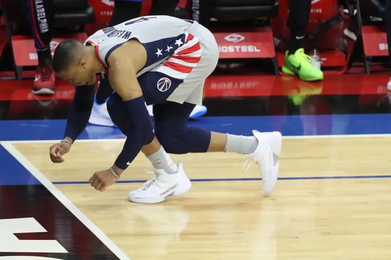 Washington's Russell Westbrook goes down after hurting his ankle during Game 2 against the Sixers Wednesday at the Wells Fargo Center.