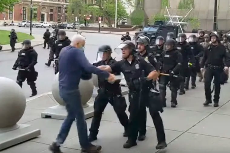 In this image from video provided by WBFO, a Buffalo, N.Y., police officer appears to shove a man who walked up to police Thursday. The video shows the man appearing to hit his head on the pavement, with blood leaking out of an ear as officers walk past to clear Niagara Square.