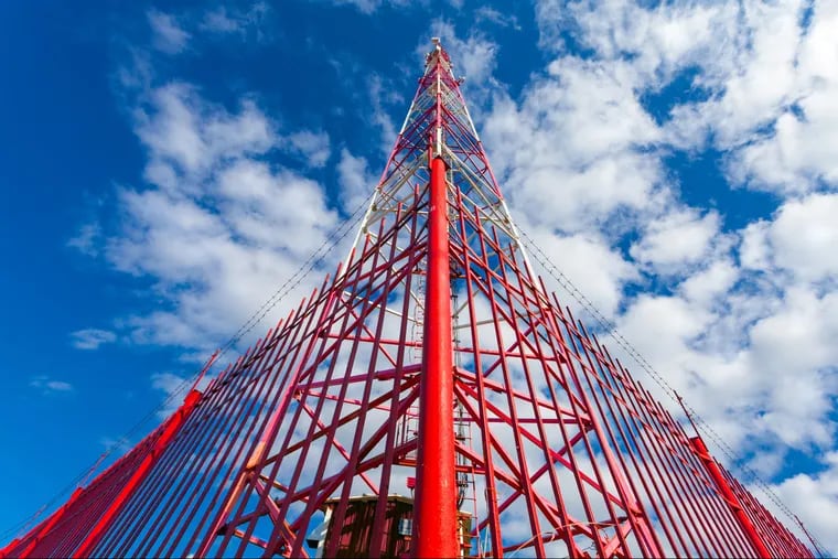 A telecommunication tower with panel antennas and radio antennas and satellite dishes for mobile communications. Telecom companies are seeking ways to rapidly deploy 5G technology but there are many critics.