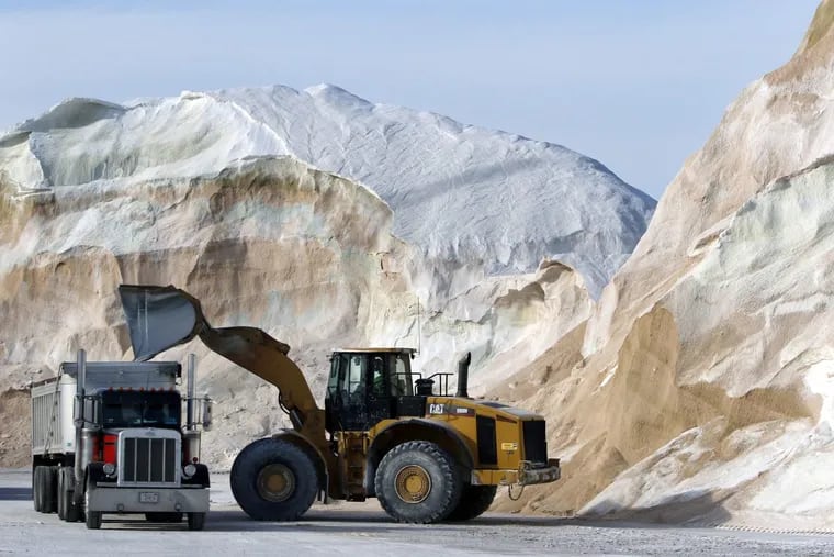 Road salt is loaded into a truck surrounded by mountains of salt at Eastern Minerals Inc., on Wednesday in the Boston suburb of Chelsea, Mass. in preparation for blizzard warnings.