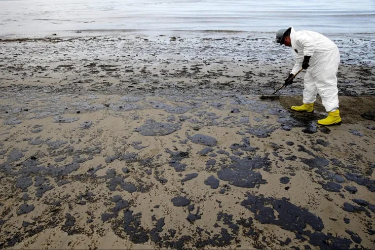 A worker removes oil from the sand at Refugio State Beach in the Santa Barbara Channel, north of Goleta, Calif., one month after a massive oil spill in May 2015.  The Trump administration has moved to vastly expand offshore drilling from the Atlantic to the Arctic oceans with a plan that would open up federal waters off the California coast for the first time in more than three decades.