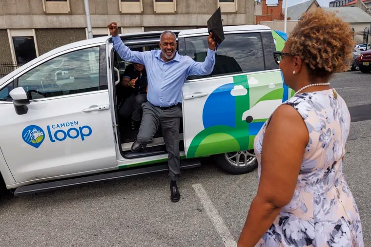 Camden Mayor Victor Carstarphen gets out of a Camden Loop minivan. In the foreground is Dana Redd, president and CEO of Camden Community Partnership.