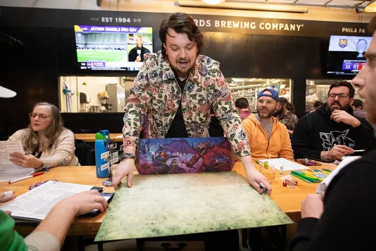Dungeon M=master Zackary "J.J." Salamon lays out a game of Dungeons & Dragons at Yards Brewing Company at 500 Spring Garden Street on March 27, 2024. Salamon works with Dungeons n Drafts, a roving DnD league based in Philadelphia that hosts introductory pop-ups at bars throughout the city.