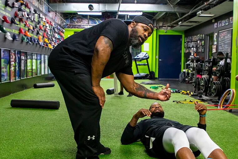 Greg Garrett, 46, of West Philadelphia,owner and head strength coach at Level 40 Training & Performance Center, works with NBA player Marcus Morris; his brother, Markieff; and B.J.. Johnson, in July. Garrett has owned the facility for seven years and has trained the Morris twins for about five years. "We build relationships like no other," Garrett said. "That bond that you get and to see these guys from nothing to big time athletes."