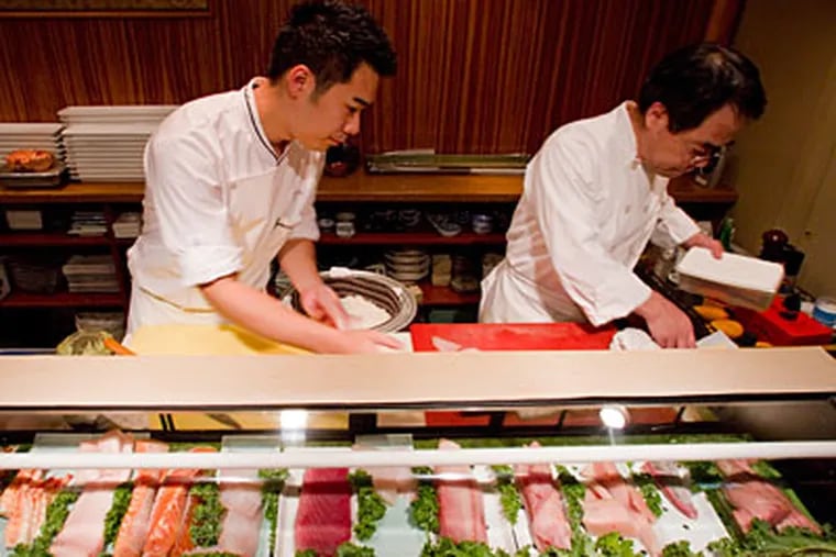 Jesse Ito and his father, Matt, a team at the sushi bar. The son worked his way up from teen dishwasher to head sushi chef. (David M Warren / Staff Photographer)
