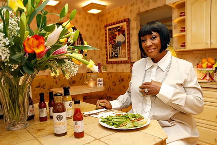 Performer Patti LaBelle with a dish she prepared in her Wynnewood home on Wednesday, May 21, 2014. The dish consisted of a branzino fish, sautéed sugar snap peas and tomatoes, accompanied by her bottle sauces from Walmart.  (Yong Kim/Staff Photographer)