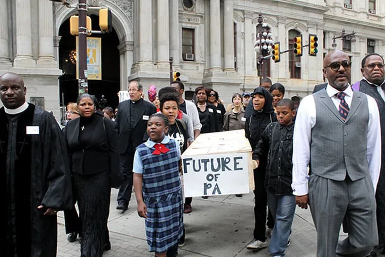 Members of Philadelphians Organize to Witness, Empower and Rebuild (POWER) and local school children march a fake casket down Broad Street during a mock funeral held for the Philadelphia School District as part of a demonstration at City Hall in Philadelphia on Friday, May 9, 2014. ( COURTNEY MARABELLA / Staff Photographer )