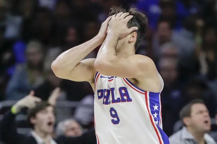 Sixers forward Dario Saric covers his face after committing a third-quarter offensive foul against the Golden State Warriors on Saturday.