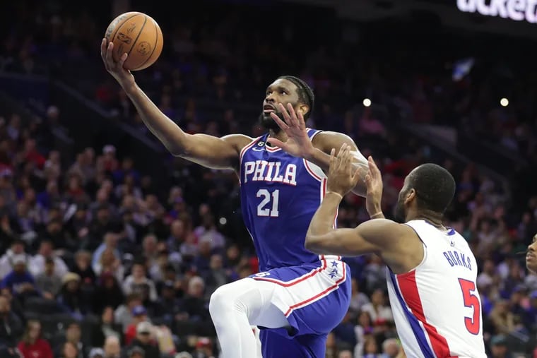 Joel Embiid (left) of the Sixers goes up for a basket against Alec Burks of the Pistons during the second half of their game at the Wells Fargo Center on Tuesday. The Sixers won, 147-116.