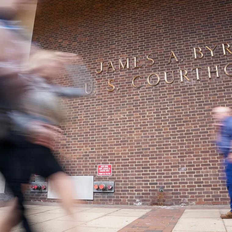 Pedestrians walk by the James A. Byrne Federal Courthouse on Oct. 22, 2021.
