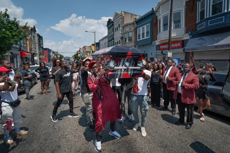 Pallbearers carry the casket of Sircarr Johnson Jr. down 60th Street, in Philadelphia, Saturday, July 17, 2021, after the viewing. They walked the casket carrying Johnson in front of the clothing store he owned.
