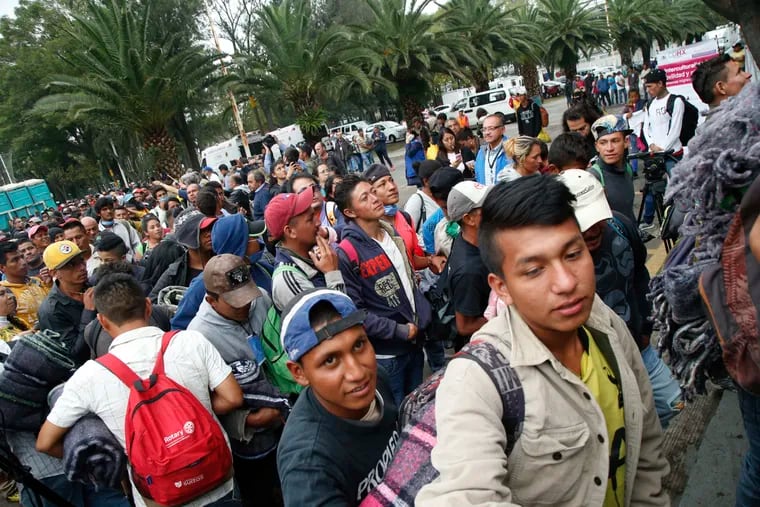 Central American migrants who splintered off a U.S.-bound caravan, file into a sporting center that has been turned into a shelter for them in Mexico City, Sunday, Nov. 4, 2018. The migrants now aim to regroup in the Mexican capital, seeking medical care and rest while they await stragglers.