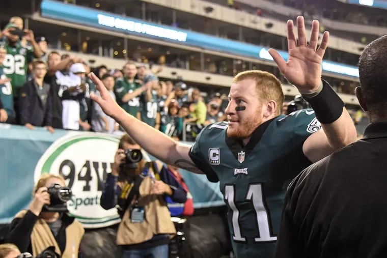 Eagles quarterback Carson Wentz waves his arms to the fans as he leaves the field after the Eagles beat the Washington Redskins, 34-24, at Lincoln Financial Field.