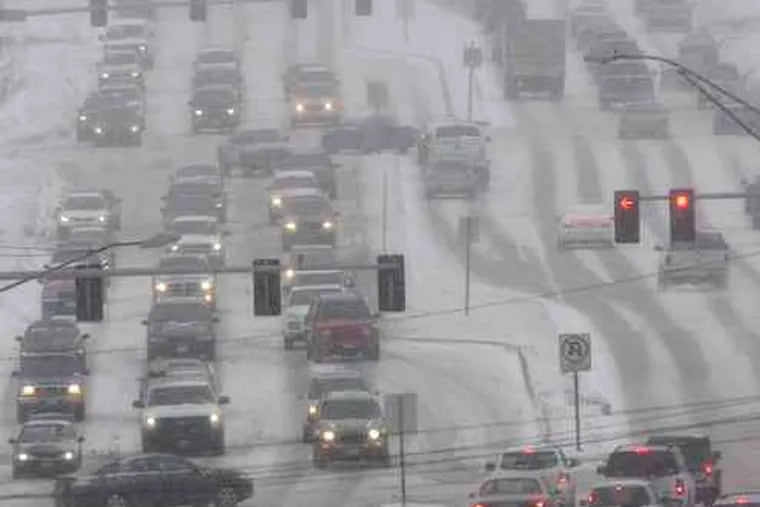 Vehicles creeping along in blizzard conditions on Dodge Street in Omaha, Neb. Forecasterssaid parts of Nebraska and several other states could expect continued snow through today.