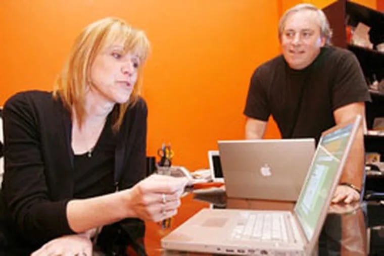 Sarah Chambers, who owns iFractal L.L.C. in Center City with Frank Roche, says their Comcast Web connection cuts out every day. (SARAH J. GLOVER / Inquirer Staff Photographer)