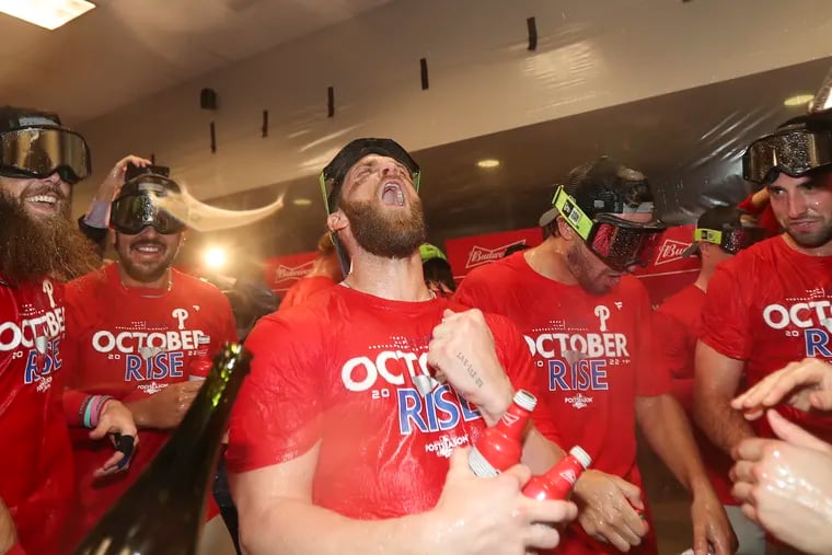 Phillies designated hitter Bryce Harper yells with his teammates after the Phillies beat the St. Louis Cardinals in the 2022 National League wild-card series.