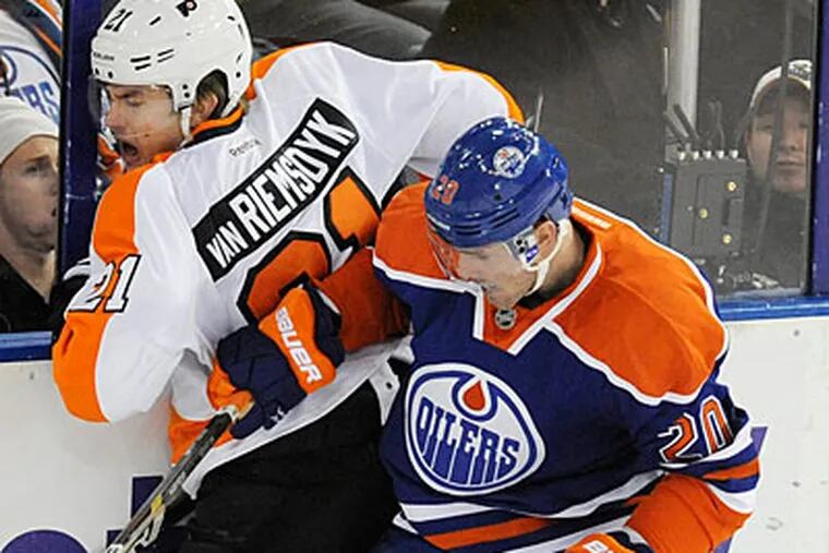 James van Riemsdyk gets checked into the boards by the Oilers' Eric Belanger. (John Ulan/The Canadian Press/AP)