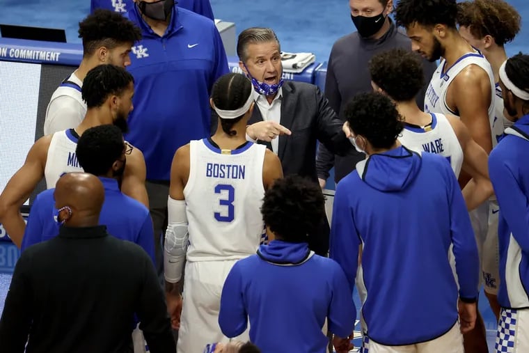 John Calipari, the head coach of the Kentucky Wildcats, gives instructions to his team.