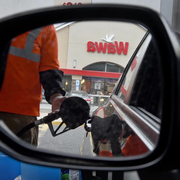 A driver's view in the rearview mirror as a full-service gas attendant fills the tank at the pump at a Wawa in Pennsauken, N.J April 2020.
