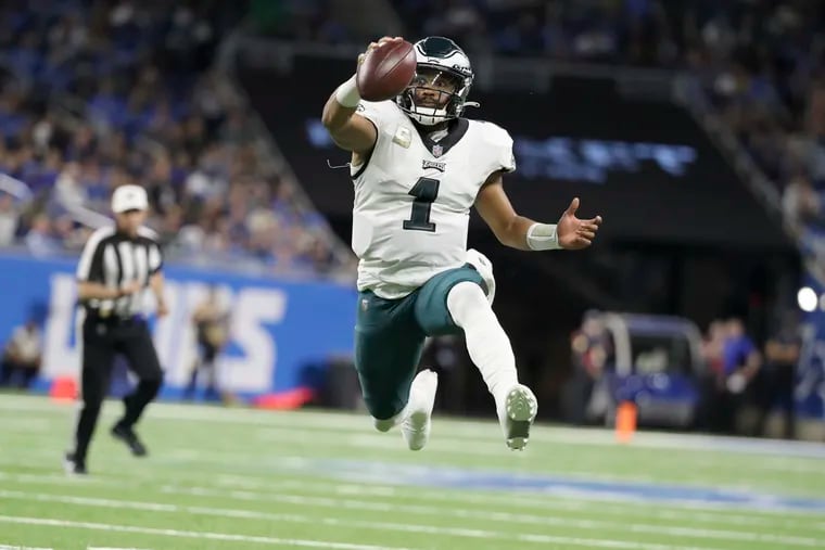 Philadelphia Eagles quarterback Jalen Hurts (1) leaps into the air like he is going to throw a pass, he keeps the ball and runs it into the red zone setting up the Eagles for a touchdown in the second quarter Sunday, October 31, 2021 at Ford Field in Detroit, Michigan.