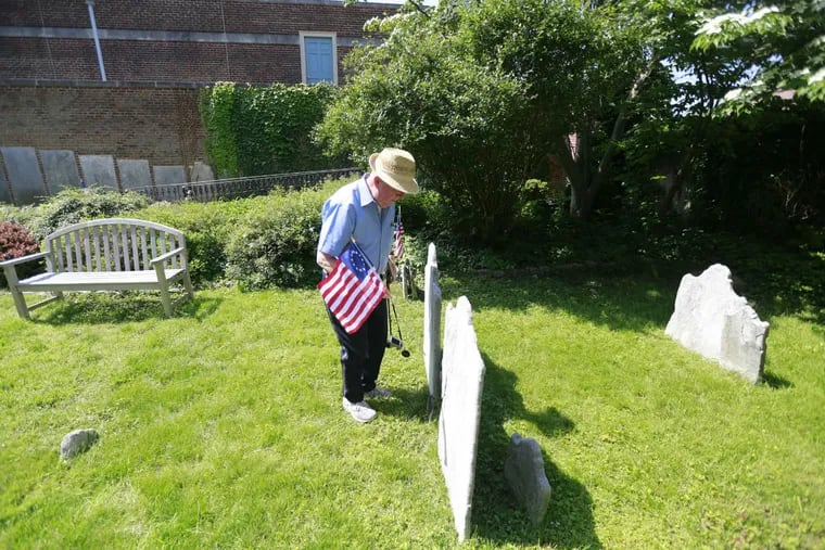 Ronn Shaffer replaces a flag at the Old Pine Street Presbyterian Church cemetery. Shaffer devotes his retirement to identifying Revolutionary War veterans buried in the graveyard.
