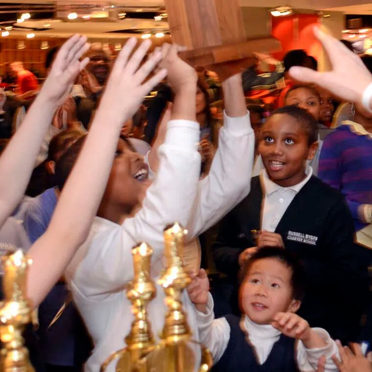 Members of the Russell Byers Charter School chess team reach for their first-place elementary school city chess championship award at the Philadelphia Scholastic Chess League City Championships in 2013.