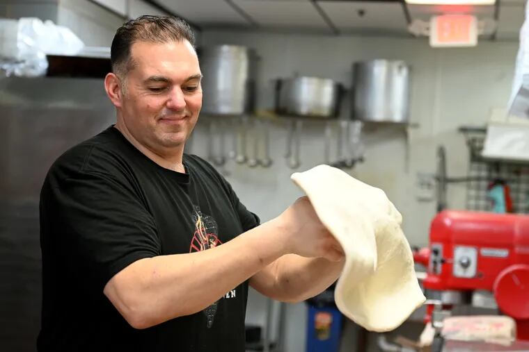 Damien Polizzi stretches a pizza in the kitchen at Polizzi's Brick Oven in Washington Township, N.J.
