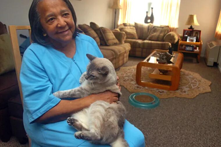 Clara McLeod, with Tiger, in her unit in Grays Ferry last week. Her eviction was called off after the People Paper made calls to PHA and HUD. (Sarah J. Glover / Staff Photographer)