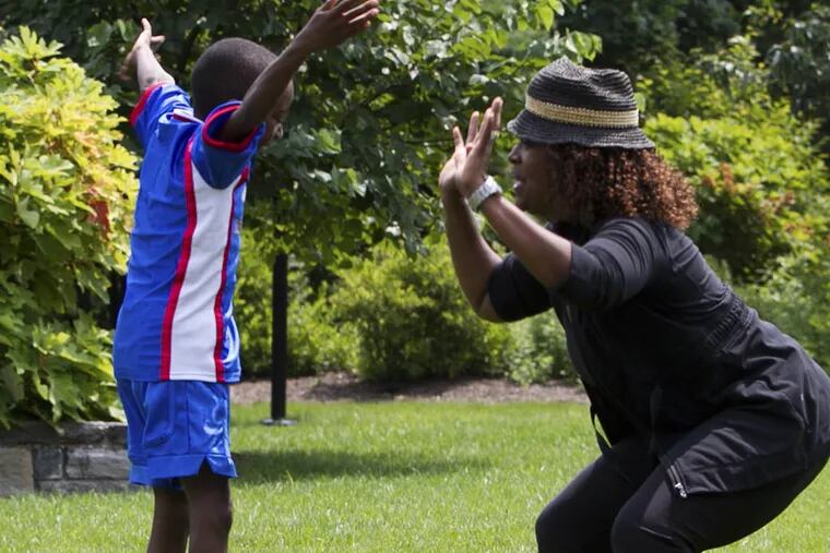 Fitness expert Kimberly Garrison and son Darius demonstrate Frog Jump exercise at Independence Mall park on Tuesday, July 29, 2014. ( ALEJANDRO A. ALVAREZ / STAFF PHOTOGRAPHER )