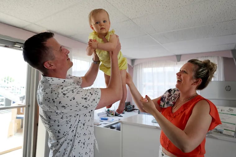 Paul Pawlowski plays with his daughter, Juliana, as his wife, Alethea, watches in her office at her family’s motel in Wildwood Crest, N.J. on Sunday, July 17, 2022. .
