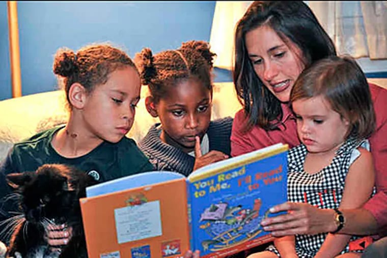 Michelle Loucas and her husband will start the democratic-model school. She reads to daughter Pepper, 3, and neighbor twins Eve (left) and Ada Skilton-Sylvester, 8. (Sharon Gekoski-Kimmel/Staff)