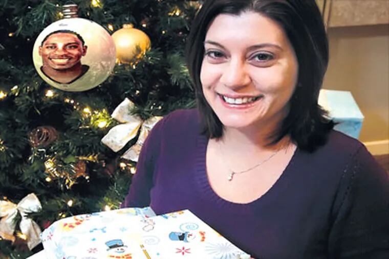 Jennifer Santoro with the Christmas presents Ellis Hobbs bought for her family at Toys 'R' Us. (Photo illustration: Stephen M. Falk / Staff Photographer)