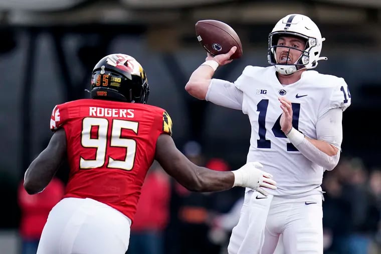 Penn State quarterback Sean Clifford (14) throws the ball while being hurried by Maryland defensive lineman Lawtez Rogers (95) during the first half of an NCAA college football game, Saturday, Nov. 6, 2021, in College Park, Md.