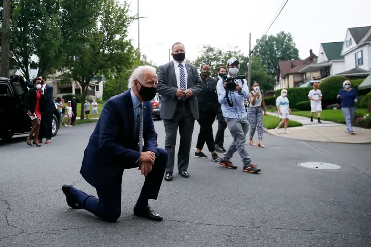 Democratic presidential candidate, former Vice President Joe Biden kneels to talk with a child during a visit to Biden's childhood home in Scranton, Pa., on Thursday, July 9, 2020. (AP Photo/Matt Slocum)