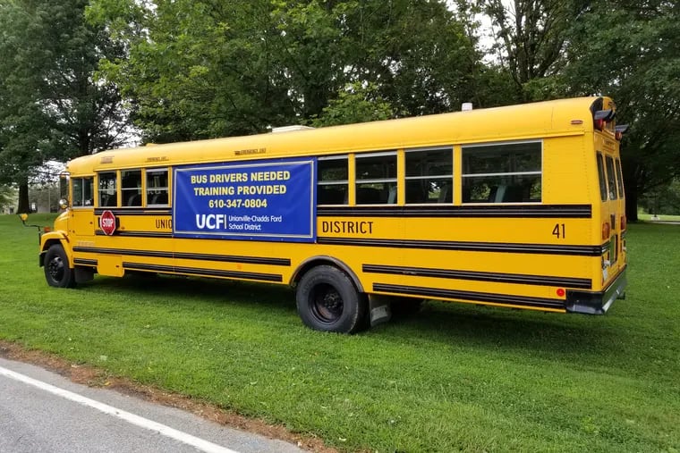 A school bus parked in front of the middle and high school in the Unionville-Chadds Ford School District this summer advertised openings for drivers. Districts around the region are struggling with a national school bus driver shortage.