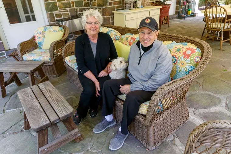 Leslie and Tom Sodano with their dog Lulu, on the porch of their home in Tobyhanna. They have a view of Lake Naomi, across the road. Leslie made the colorful seat cushions.