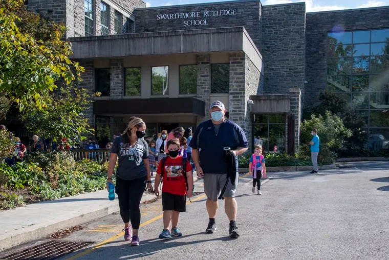 Christine Anderson (left) and Ron Contrady reunite with their son, R.J. Contrady, 6, at the end of the day at the Swarthmore-Rutledge Elementary School in Swarthmore on Monday.
