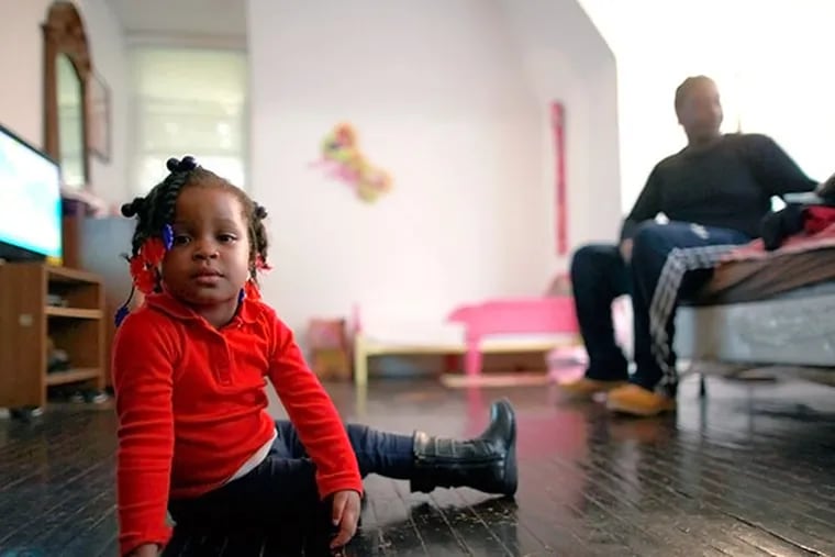 Maziah Mills-Sorrells, 2, plays with her father, Raashid Sorrells, 24, in their one-bedroom apartment October 30, 2013. Her left arm was paralyzed during childbirth and she has been denied federal Supplemental Security Income child disability benefits three times by the Social Security Administration. ( DAVID SWANSON / Staff Photographer )
