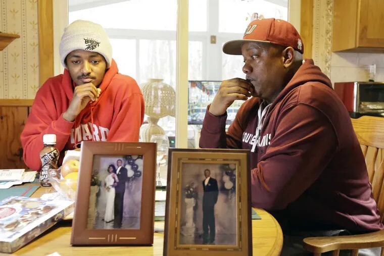 Saleem Little (left) and his father Theodore Little talk about slain brother/son Rashaun Julius Nelson (pictured in foreground) at their Deptford home.