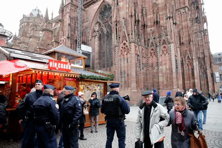 French police officers patrol outside the cathedral as the Christmas market reopens in Strasbourg, eastern France, Friday, Dec.14, 2018. The man authorities believe killed three people during a rampage near a Christmas market in Strasbourg died Thursday in a shootout with police at the end of a two-day manhunt, French authorities said. (AP Photo/Christophe Ena)