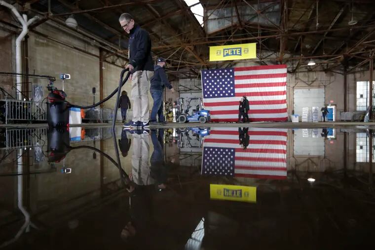 A volunteer vacuums water on the floor as they prepare for the announcement by Pete Buttigieg that he will seek the Democratic presidential nomination before a rally in South Bend, Ind., Sunday, April 14, 2019. Buttigieg, 37, is serving he second term as the mayor of South Bend. (AP Photo/Michael Conroy)
