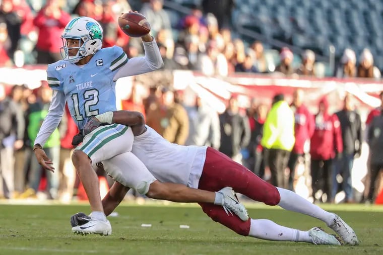 Tulane quarterback Justin McMillan got this pass off before he was brought down by Temple defensive end Quincy Roche in the fourth quarter Saturday.