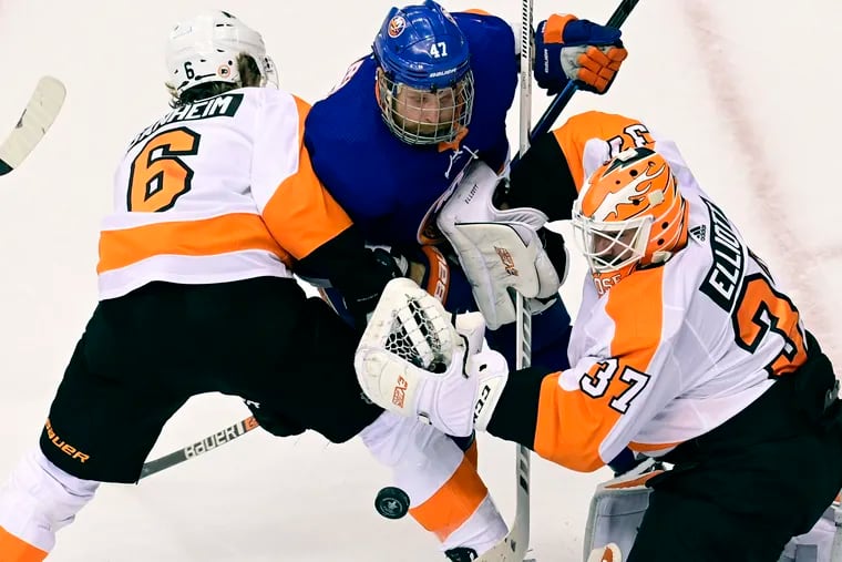 New York Islanders forward Leo Komarov (47) and Flyers defenseman Travis Sanheim (6) battle for position in front of goaltender Brian Elliott on Sunday night. The Islanders outlasted the Flyers, 3-2.