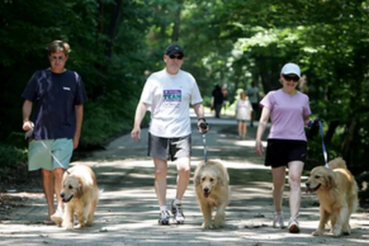 On a stroll at Ridley Creek State Park with their golden retrievers , Frank Baer (left), and Mel and Valerie Burgis were musing yesterday on where they&#0039;ll walk their dogs if Pennsylvania&#0039;s state parks are closed today because of a government shut-down.