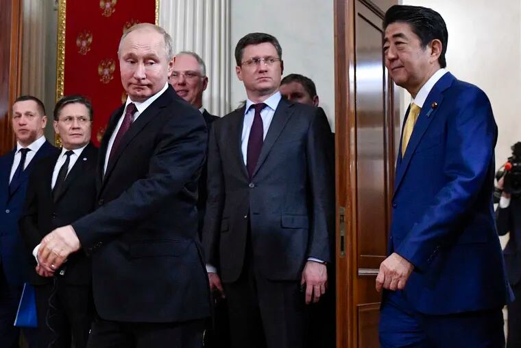 Russian President Vladimir Putin, foreground left, and Japanese Prime Minister Shinzo Abe, right, enter a hall for their joint news conference following the talks in the Kremlin in Moscow, Russia, Tuesday, Jan. 22, 2019. The Kremlin talks focused on a decades-long territorial dispute between the two nations. (Alexander Nemenov/Pool Photo via AP)