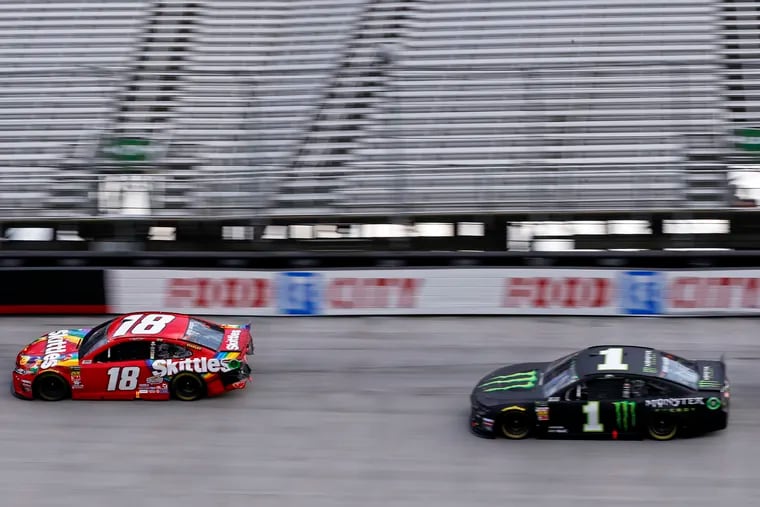 Kyle Busch (18) leads his brother Kurt Busch in the final laps of the NASCAR Cup Series auto race Sunday, April 7, 2019, at Bristol Motor Speedway in Bristol, Tenn.