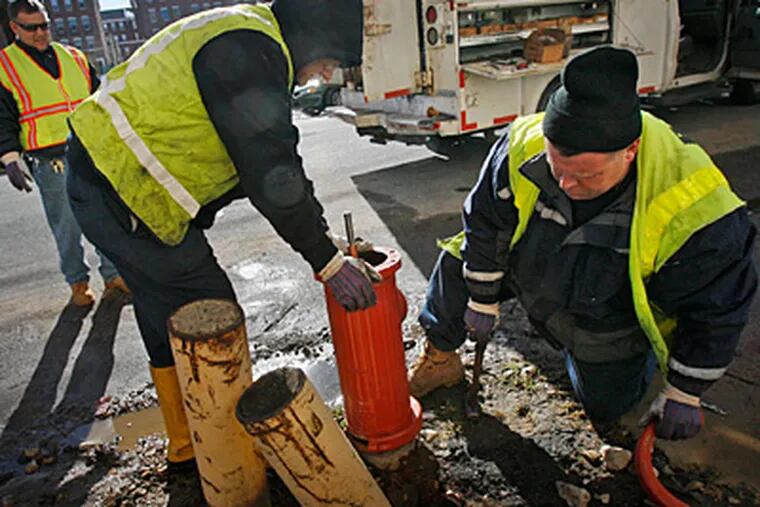 Water Dept. workers on Feb. 3 fix the hydrant at Mascher and Loudon streets that failed to work the morning of a Jan. 13 fire. (ALEJANDRO A. ALVAREZ / Staff photographer)