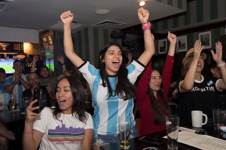 Camila Parrilla (center) reacts with other fans of Argentina as they watch the World Cup game between Argentina and Nigeria at Fado Restaurant Bar on Locust Street. ,