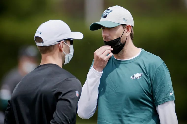 Eagles defensive coordinator Jonathan Gannon (left) talks with offensive coordinator Shane Steichen at rookie minicamp earlier in May.